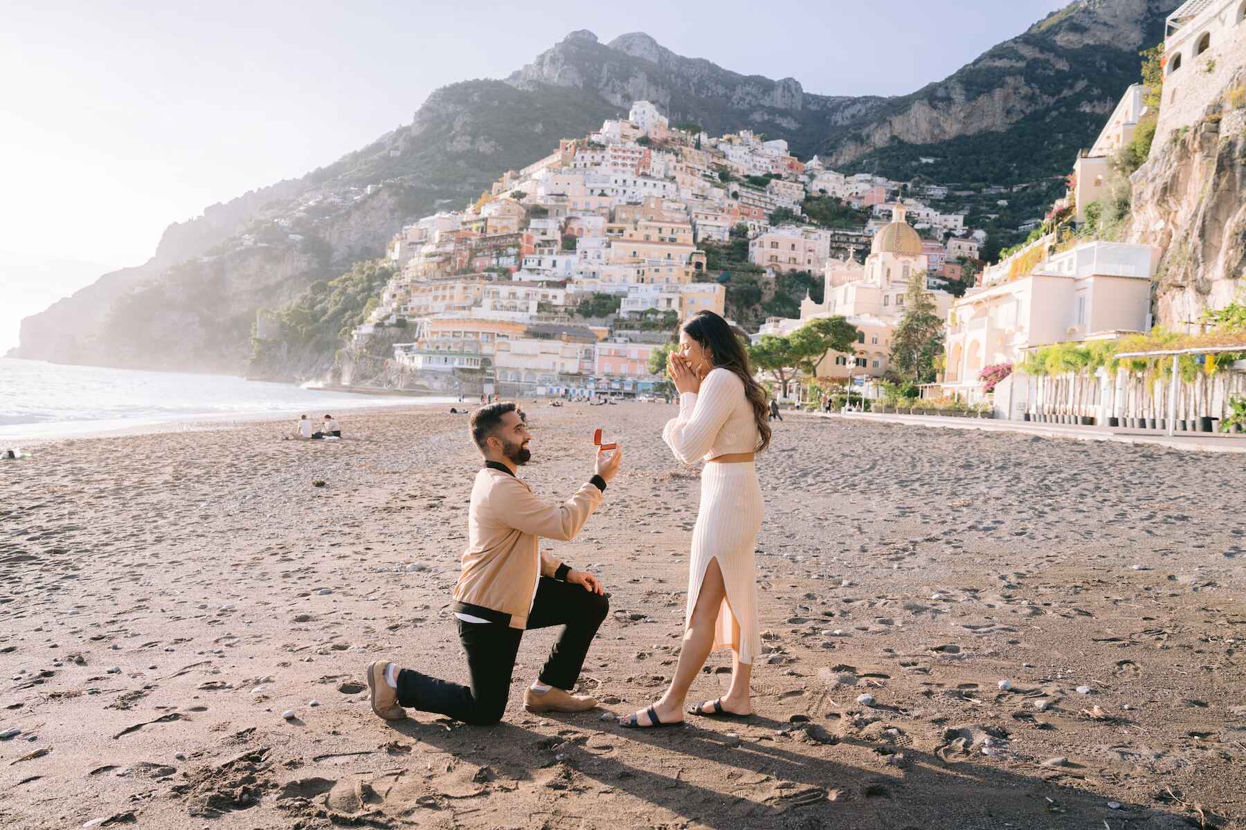Man kneeling during Positano surprise proposal photo session on the beach on the Amalfi Coast
