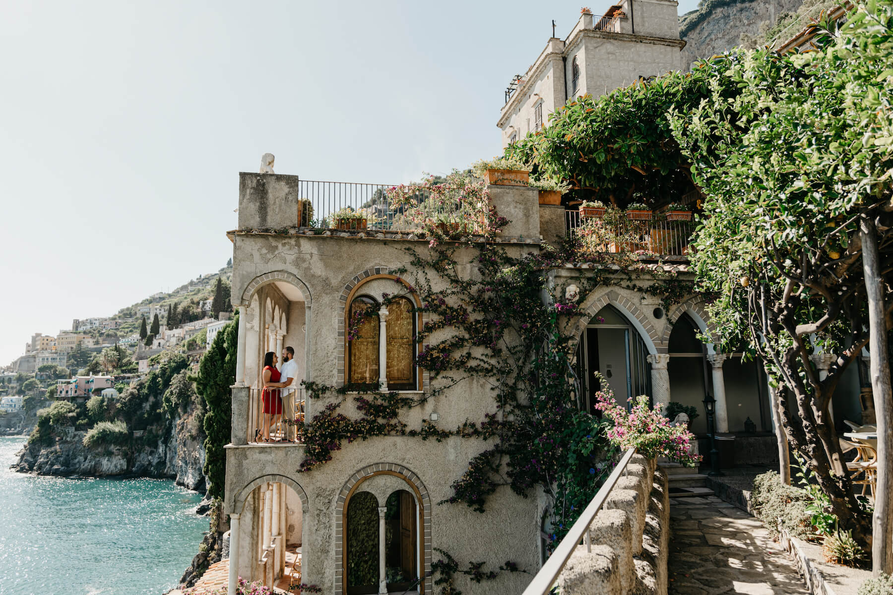 A couple sitting in a windowsill on the Amalfi Coast on a couple photoshoot with Flytographer